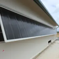 Vus de l'extérieur, les ouvrants en polycarbonate fumé dans la masse paraissent sombres.
