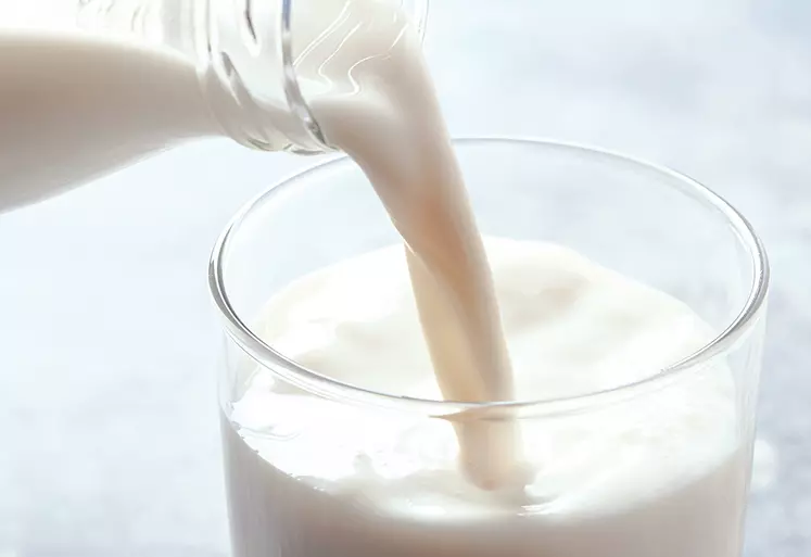 Du lait en train d'être versé dans un verre.