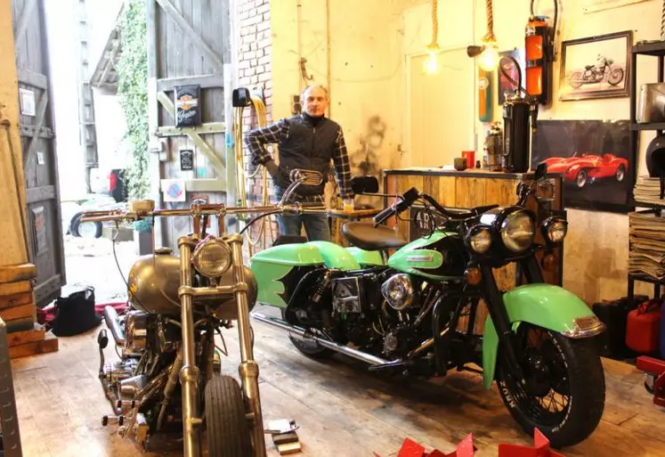 Éric Poli dans son atelier de Polminhac avec quelques-unes de ses Harley.