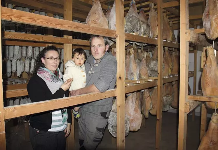 Ludivine et Sébastien Denis avec leur petit dernier dans les séchoirs de la ferme.