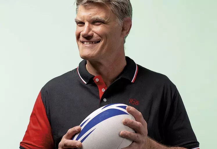 Fabien Pelous, ancien capitaine de l'équipe de france de rugby à XV, tient un ballon de rugby