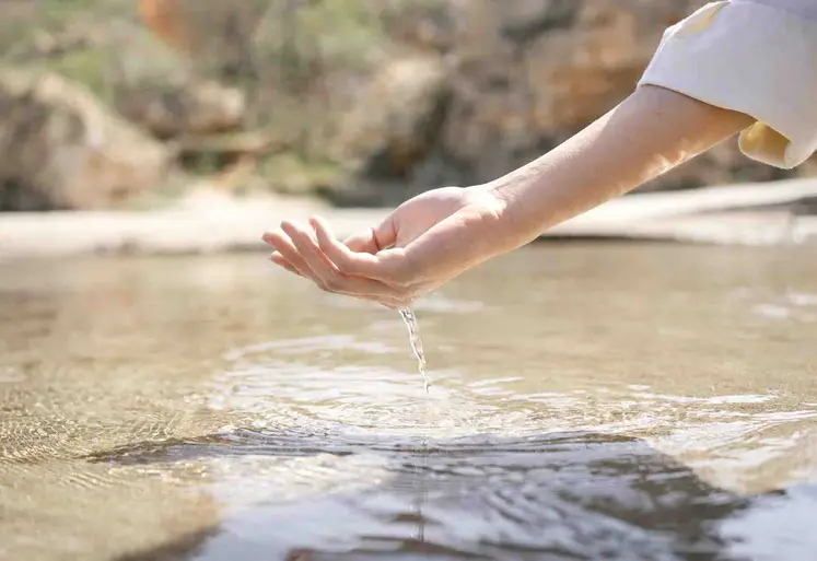 Main qui prend de l'eau dans une mare