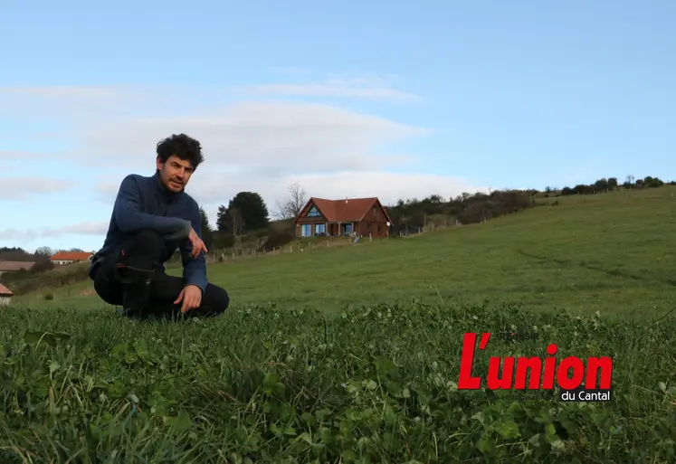 Un homme accroupi au milieu de l'herbe. 