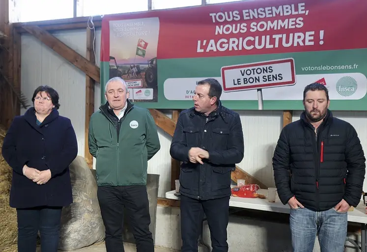 Un groupe de quatre personnes se tient devant une banderole syndicale