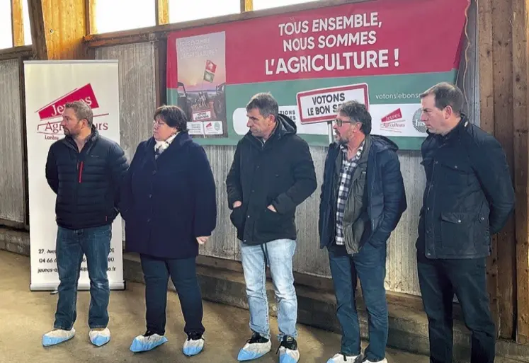 Un groupe est debout devant des affiches électorales agricoles