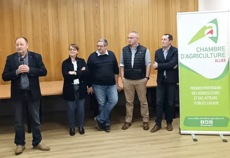 cinq personnes devant l'estrade, à côté de l'affiche de la chambre d'agriculture de l'allier