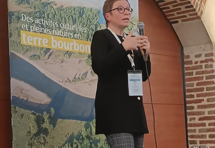 Femme debout parlant dans un micro devant une pancarte