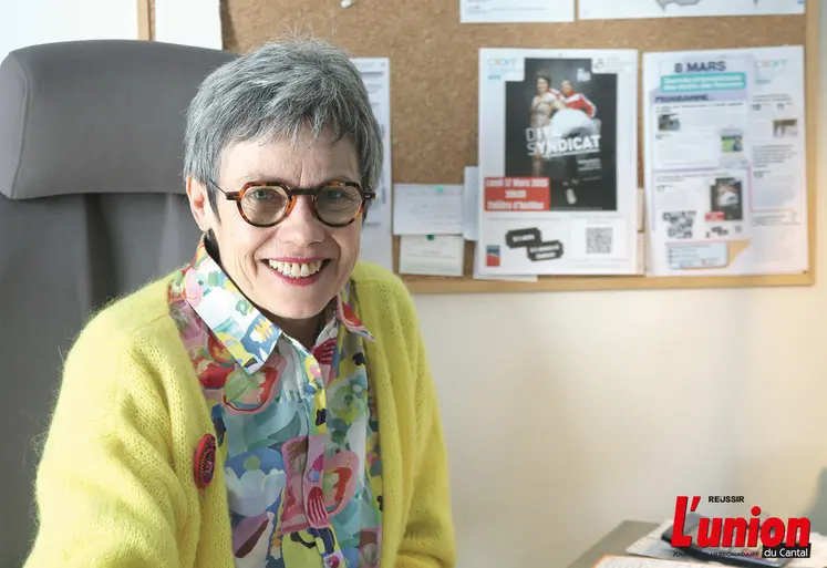 Une dame souriante assise à son bureau