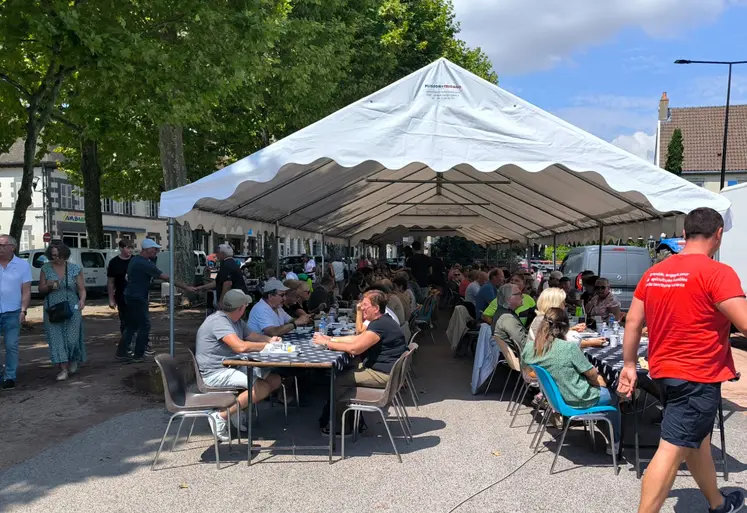 des personnes dégustent un barbecue sous un chapiteau
