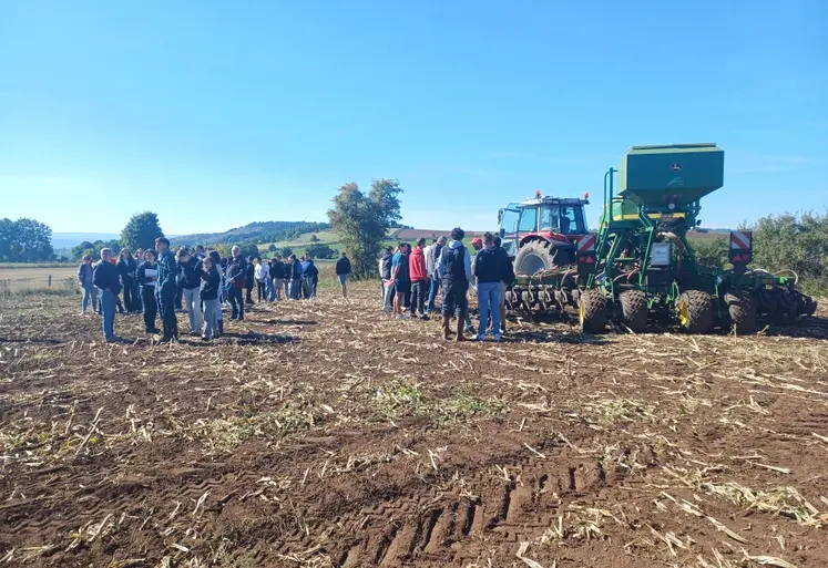 Elèves et adhérents de Cuma devant un tracteur et semoir semis-direct 6 m équipés des systèmes GPS, autoguidage, Isobus.