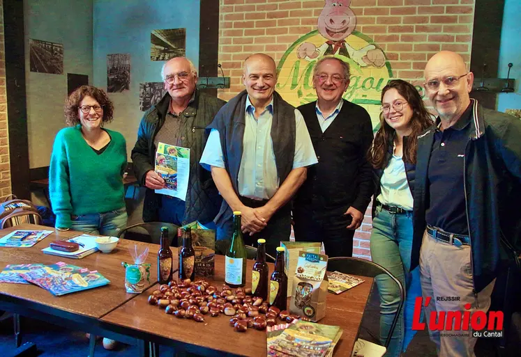 Un groupe de personnes débout, devant une table remplie de produits à la châtaigne. 