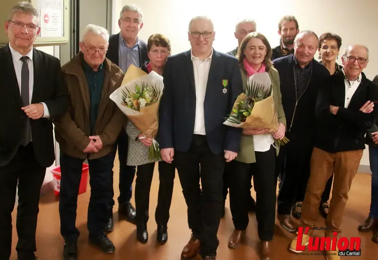 un médaillé du mérite agricole, entouré de sa famille et de responsables politiques du Cantal. 