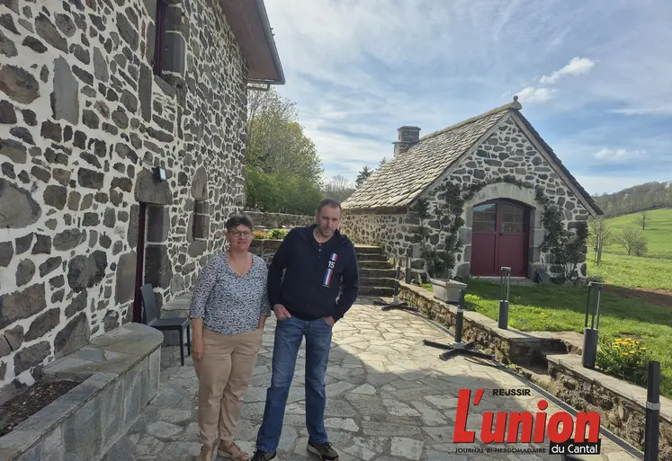 Une femme et un homme devant une maison en pierre