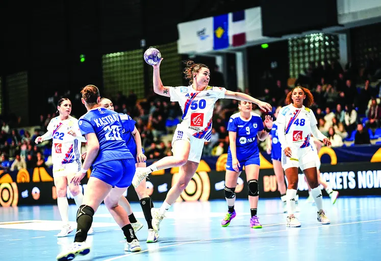 une joueuse de handball qui tente un tir en extension