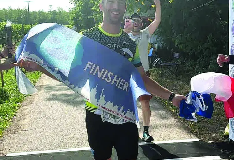 Un finisher franchit la ligne d'arrivée.