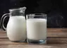 carafe de lait et verre de lait sur une table fond noir