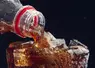 bouteille versant du soda dans un verre