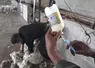 une seringue charger avec un liquide avec un mouton en train d'être tondu en arrière-plan