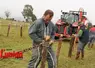 un eleveur en train d'installer une chaine autour d'un piquet en bois