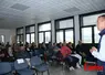 Homme debout intervant devant une assemblée de jeunes éleveurs dans une salle