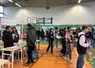 Des stands d'exposition dans un gymnase d'établissement scolaire