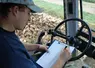 jeune salarié d'EDT au volant d'un engin agricole remplit un formulaire.