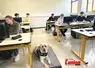 Un chien assis dans une salle de classe.