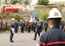 un homme avec un casque de pompier. Un homme portant un drapeau marche vers un autre homme. 