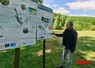 le maire du rouget devant des panneaux informatifs et un lac vide
