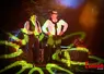 Deux personnages en costume du début du XXe siècle encerclés de lumières. 