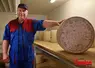 producteur de fromages dans une cave qui présente une fourme de salers AOP