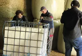 Deux personnes nouent des ficelles dans un récupérateur d'eau, filmés par un troisième
