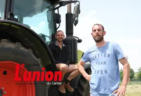 un homme assis sur un tracteur et un autre debout avec un tee shirt bleu