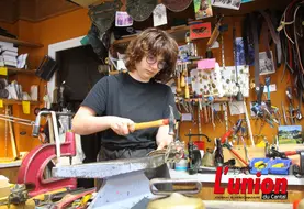 Sellière bourrelière au travail, martele les rivets d'un licol de cuir