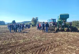 Elèves et adhérents de Cuma devant un tracteur et semoir semis-direct 6 m équipés des systèmes GPS, autoguidage, Isobus.