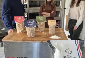 trois personnes derrière une table présentent les paquets de pâtes