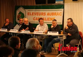 Des personnes assises derreière une table.