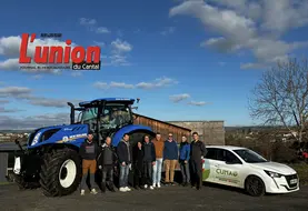 Un groupe de personnes devant un tracteur bleu.