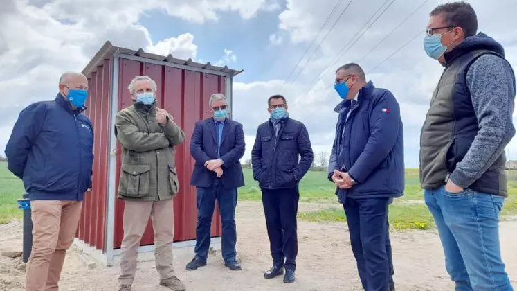 Arnaud Delbard devant la pompe de forage, aux côtés des élus.