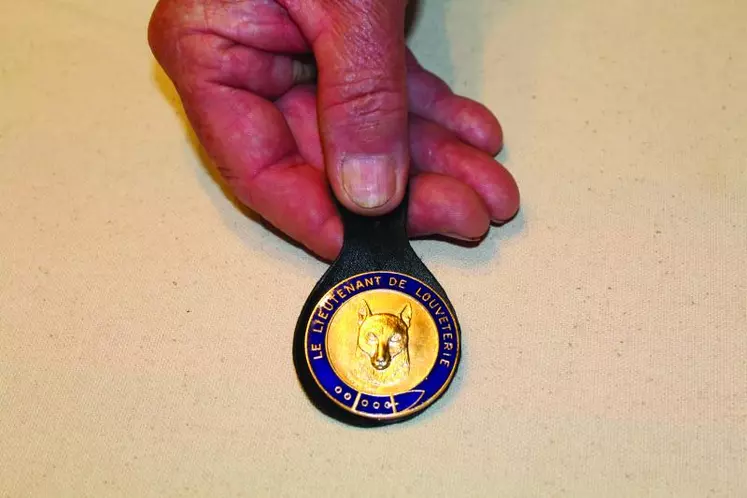 L’insigne du lieutenant de louveterie représente une tête de loup dorée avec en exergue une courroie de chasse émaillée bleue portant l’inscription « lieutenant de louveterie » en doré.