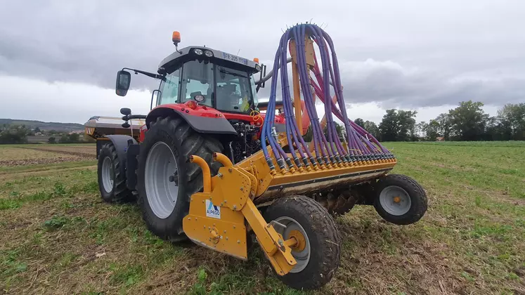 Tracteur équipé d'un semoir de technique culturale simplifiée dans un champs de maïs déchaumé.