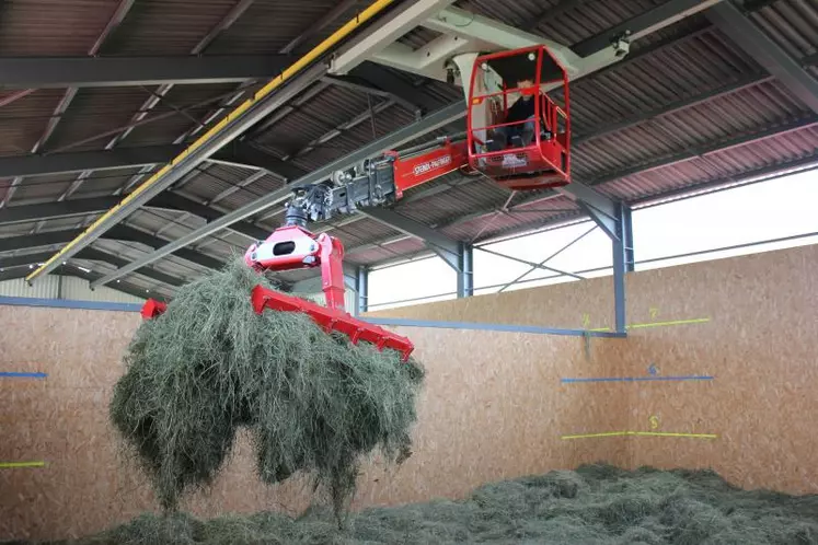 Le foin est amené à la ferme en autochargeuse puis repris à la griffe pour être stocké dans la cellule de séchage.