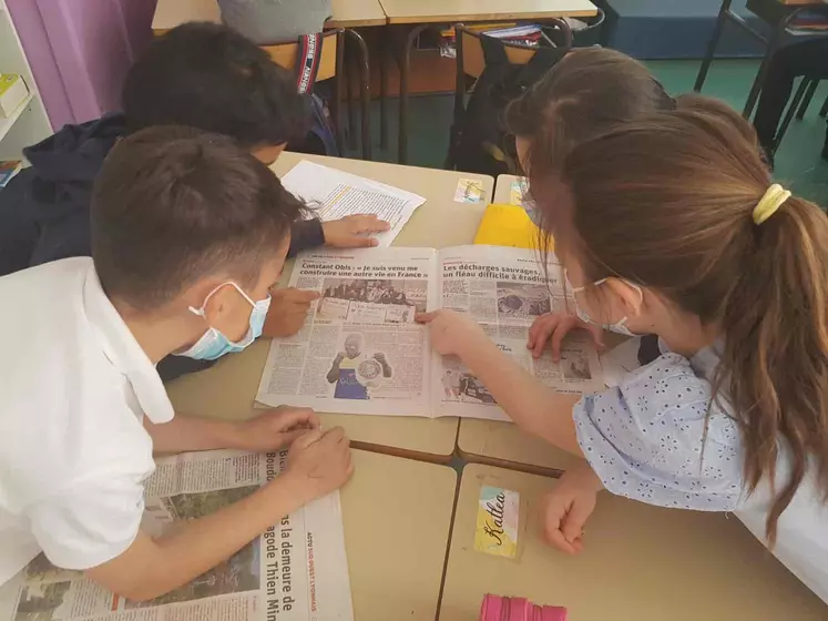 Des élèves d'une classe de CE2 à St Etienne dans la Loire feuillettent des journaux et magazines.