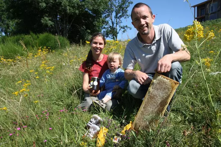 Emmanuel et Véronique avec l'un de leur deux fils sur une parcelle de prairie fleurie.