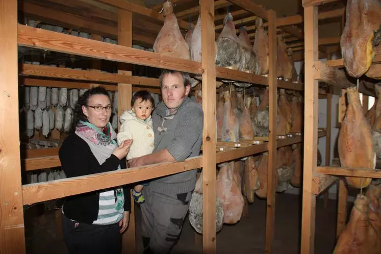 Ludivine et Sébastien Denis avec leur petit dernier dans les séchoirs de la ferme.