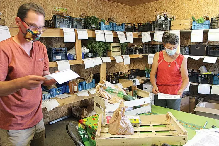 Martin Chwalek et Isabelle Amilhaud, deux producteurs du Drive fermier 15, préparent les commandes que les clients viennent chercher
en voiture.