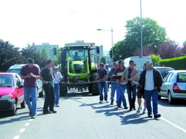 Les manifestants en train de "tirer" un tracteur à la corde.