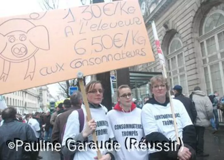 Lors de la manifestation des producteurs de porcs le 26 janvier à Paris, près de l'Assemblée nationale, des manifestantes portaient des T-Shirts "Consommateurs trompés" et une pancarte dénonçant les différences entre prix de production et prix de vente aux consommateurs.