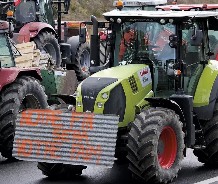 Tracteur avec un slogan affiché "Notre fin sera votre faim"