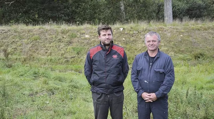 Quentin et André Sergent devant la digue de 2,5 m de haut qui encercle désormais le point bas de l’élevage et de la méthanisation.